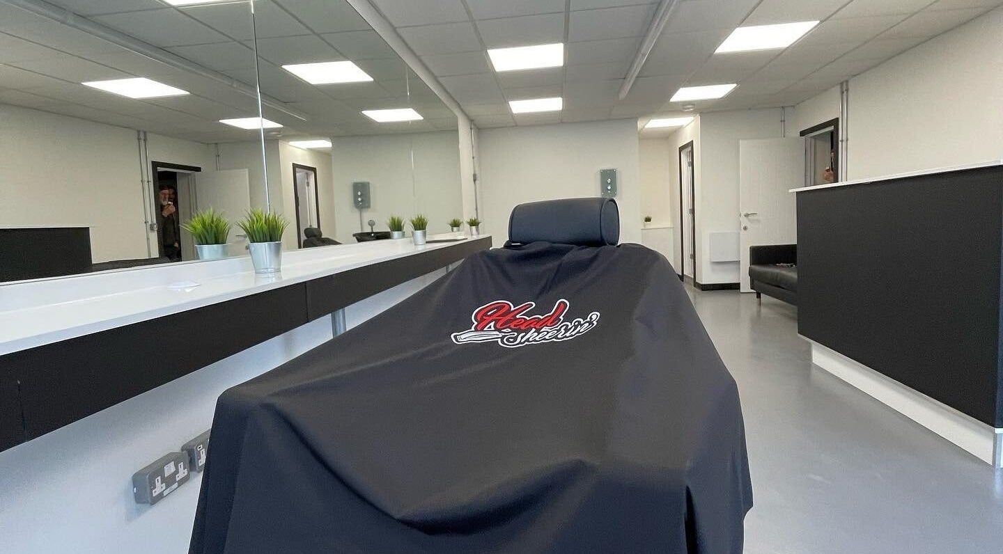 Interior of HeadsheerinHQ in Bridport, England, showcasing modern salon chair and minimalist decor.