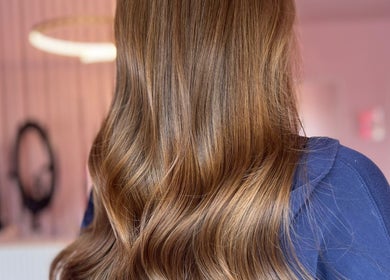 Glossy brown waves hairstyle at Hair by Susie Hancock, Ferndown, England, GB, showcasing elegant styling.