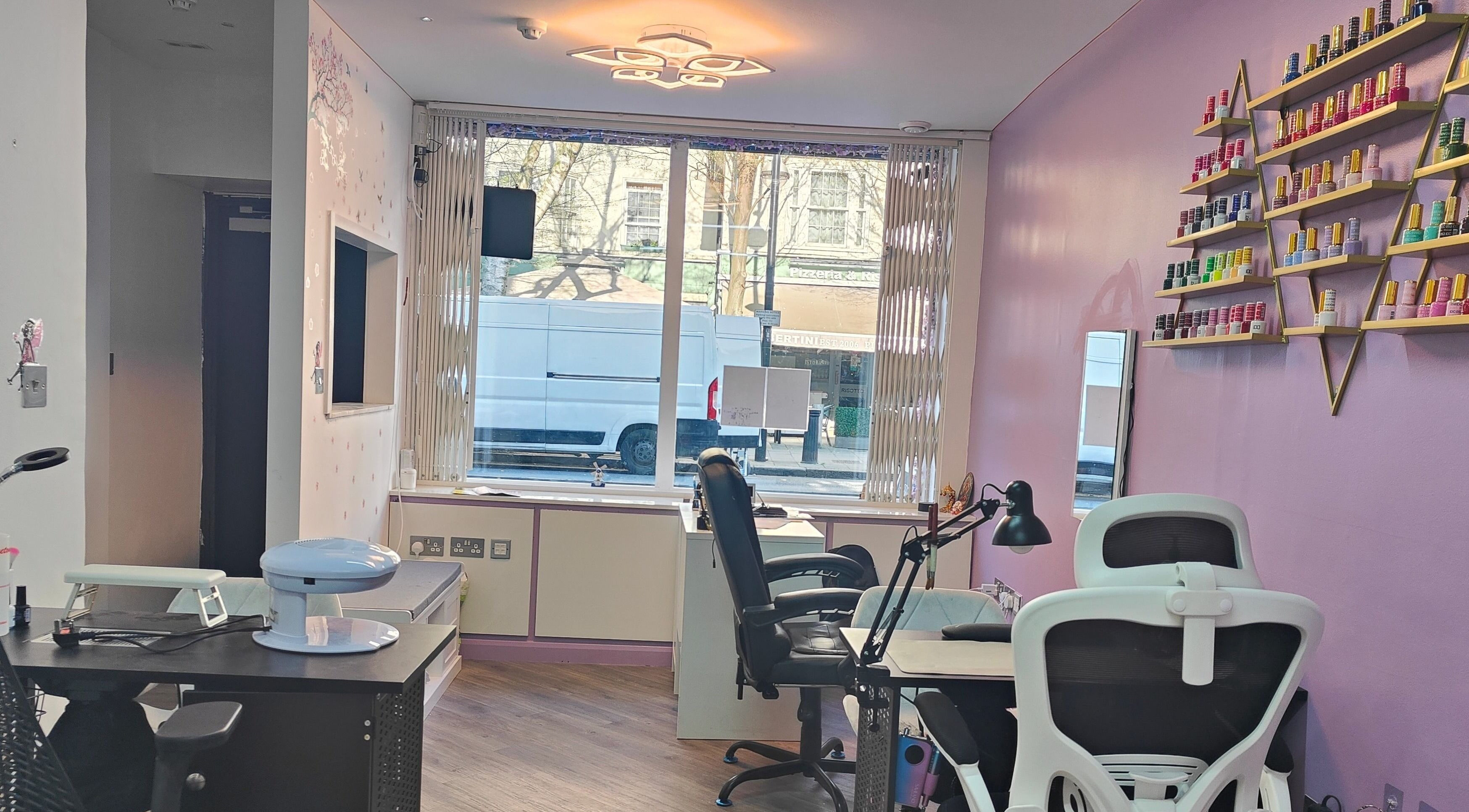 Modern nail salon interior at Elegans Nails, London, England, GB with vibrant polish display.