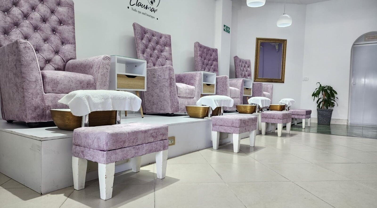 Área de belleza en Claumar Nails Spa and Boutique, La Dorada, Caldas, CO, con elegantes sillas y tinas para pies.