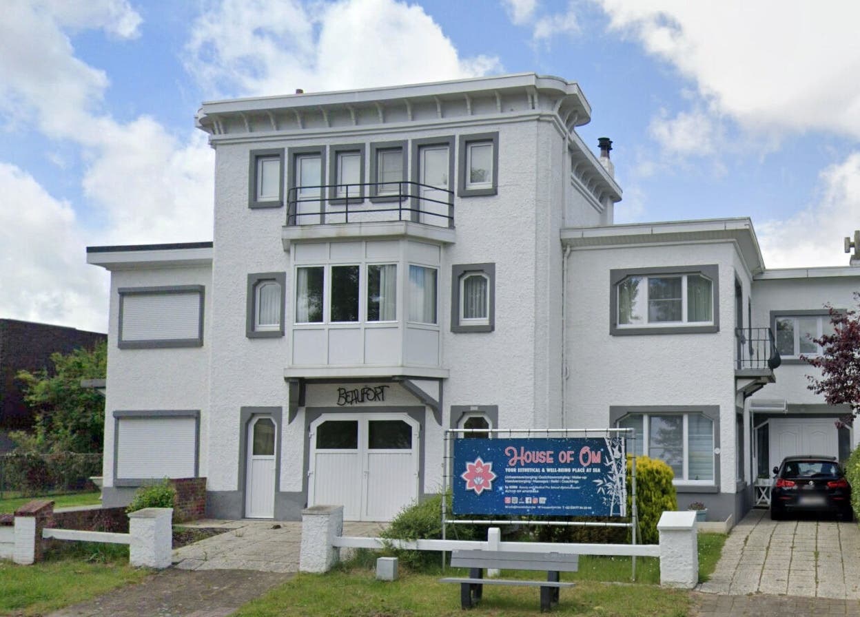 Buitengezicht van House of Om in Koksijde, Vlaams Gewest, BE, met uitnodigend bord.