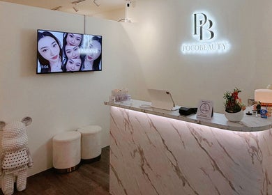Reception area of Pocobeauty in Singapore, SG with a chic marble desk and cozy seating.