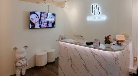 Reception area of Pocobeauty in Singapore, SG with a chic marble desk and cozy seating.