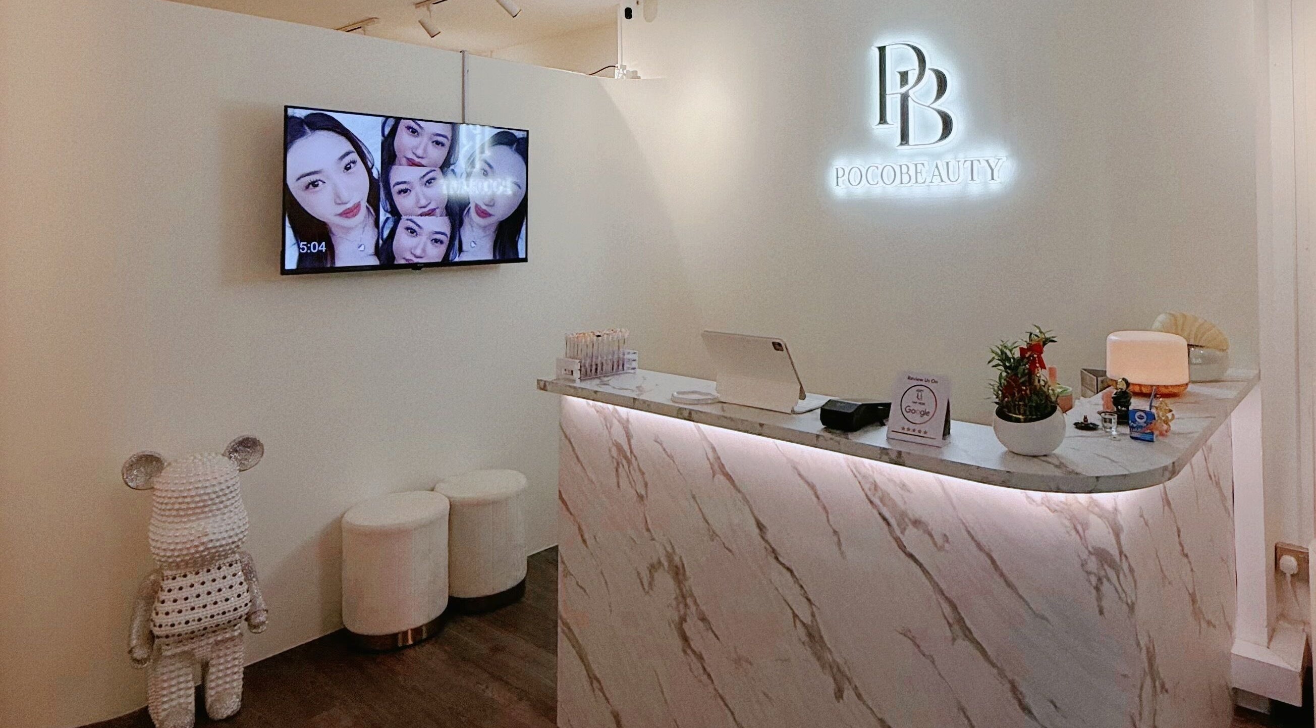 Elegant Pocobeauty reception area in Singapore with marble counter and brand sign.