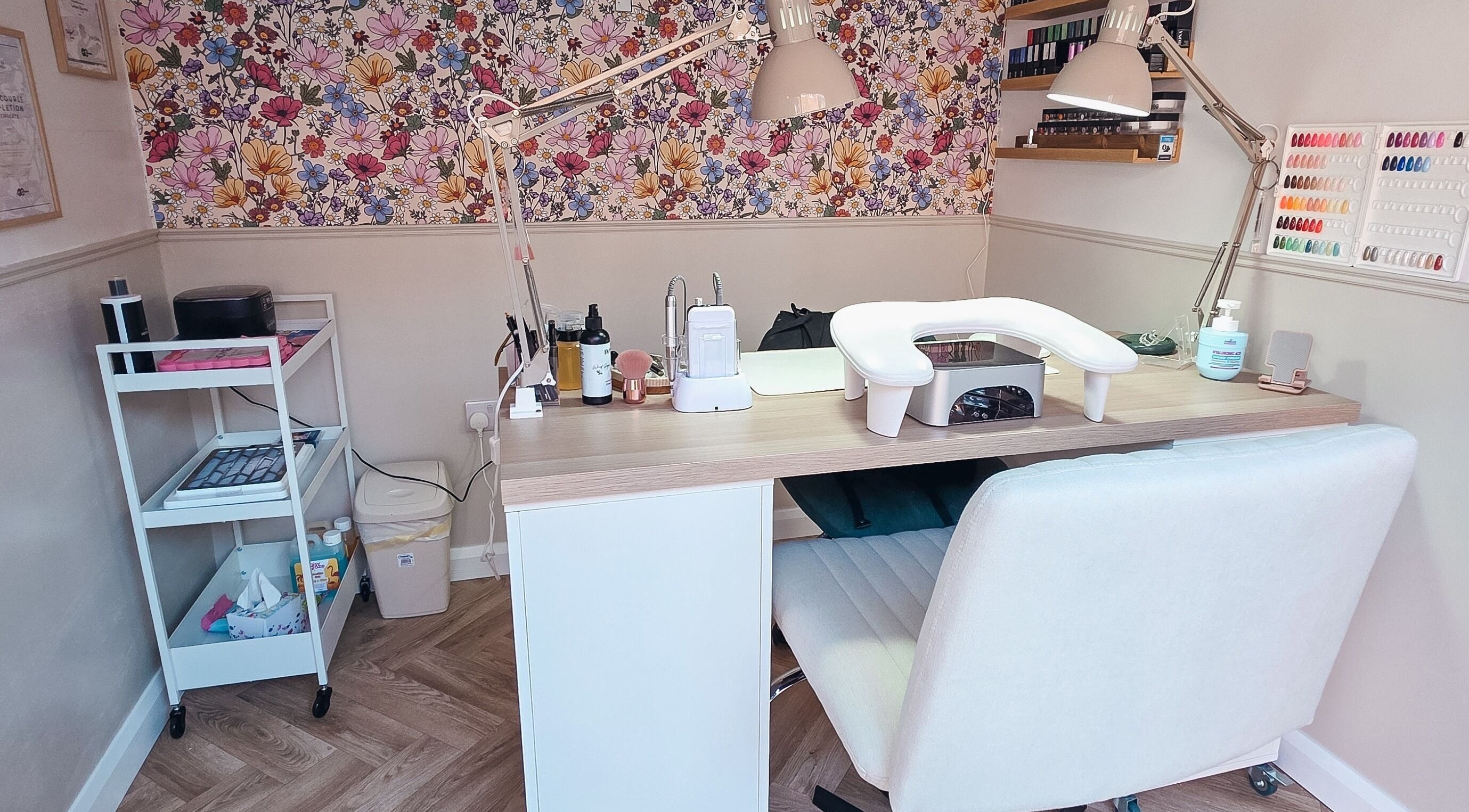 Nail workstation at Nails By Summer, Hailsham, England, GB with vibrant floral wallpaper and modern decor.