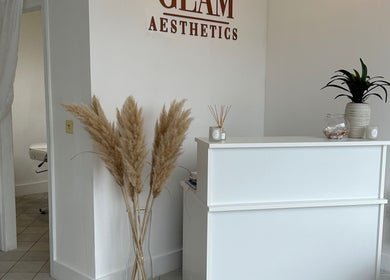Reception area of GLAM AESTHETICS- HALLE in Sidcup, England. Minimalist design with pampas grass and plants.