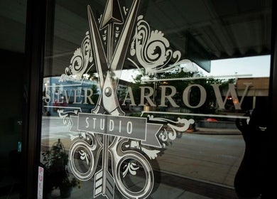 Entrance glass with Silver Arrow Studio logo at Tasha Foster's in Dixon, Illinois, US.
