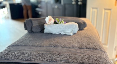 Relaxing spa table setup at Pro-Motion Sports Therapy in Crawley, England, GB, featuring soft towels and flowers.