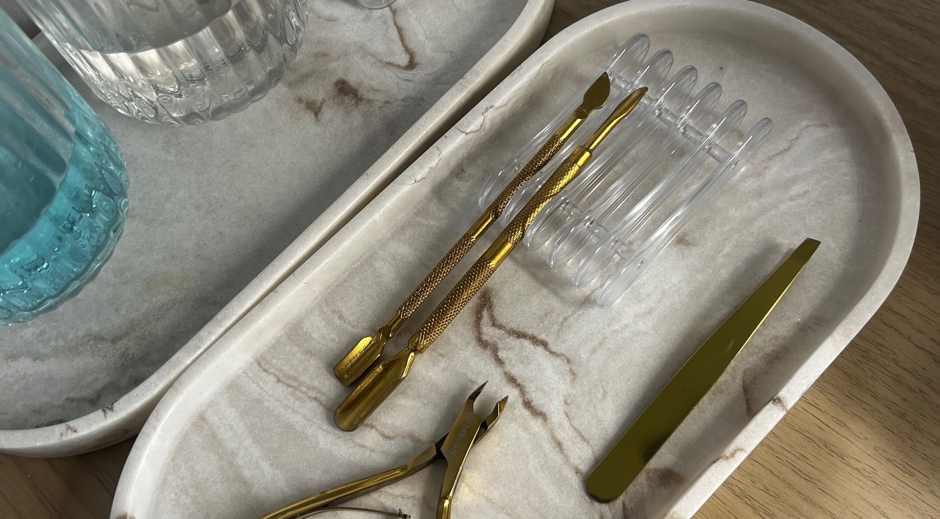 Selection of gold nail tools at No4Beauty, Sandy, England, GB on a marble tray.