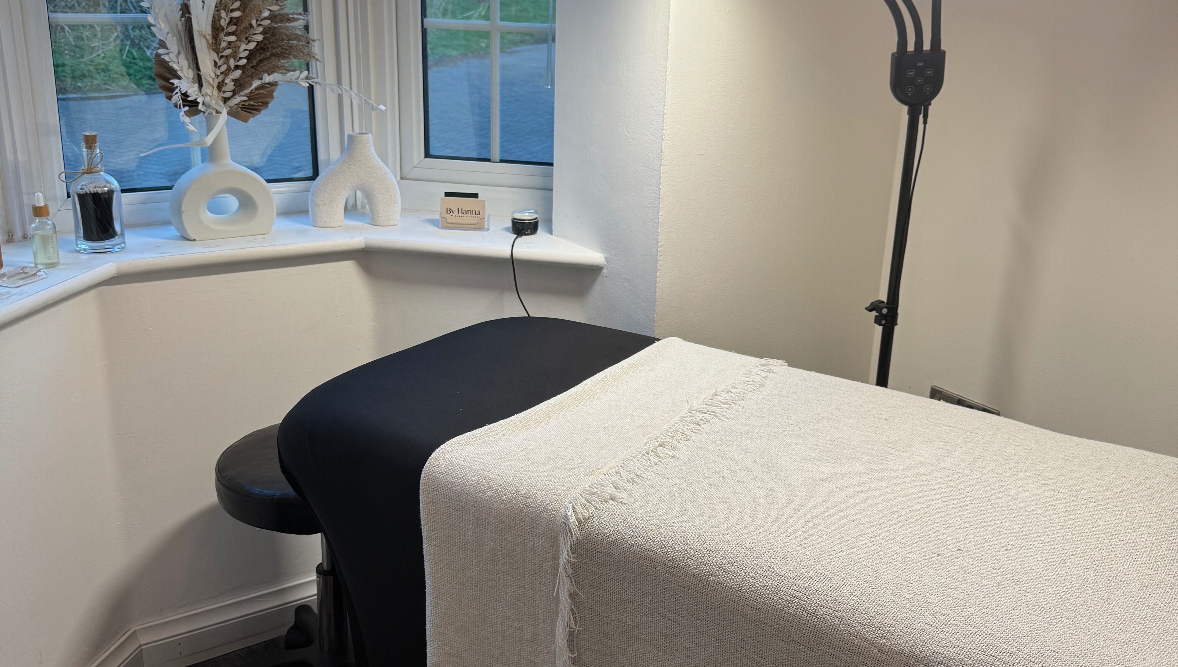A cozy wellness treatment room at The Lash Box, Bristol, England, GB, with a bed and minimal decor.