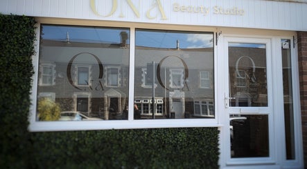 Front view of Ona Beauty Studio in Tonna, Wales, GB with stylish windows and greenery.
