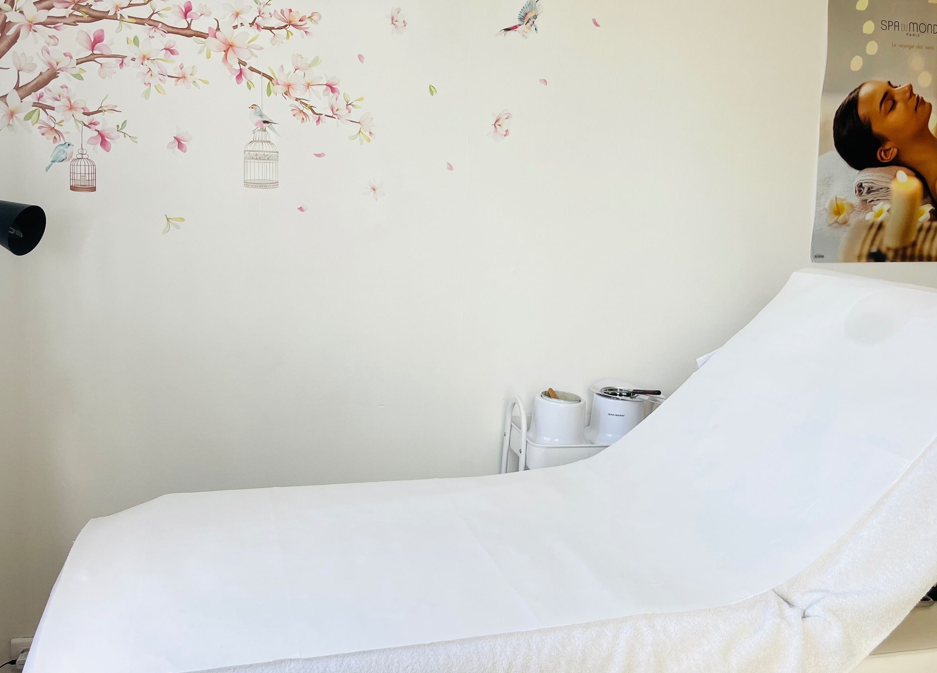 Salle de soins à Celestiminstitut, Saint-lyé, Grand Est, FR, avec lit de massage et décoration florale.