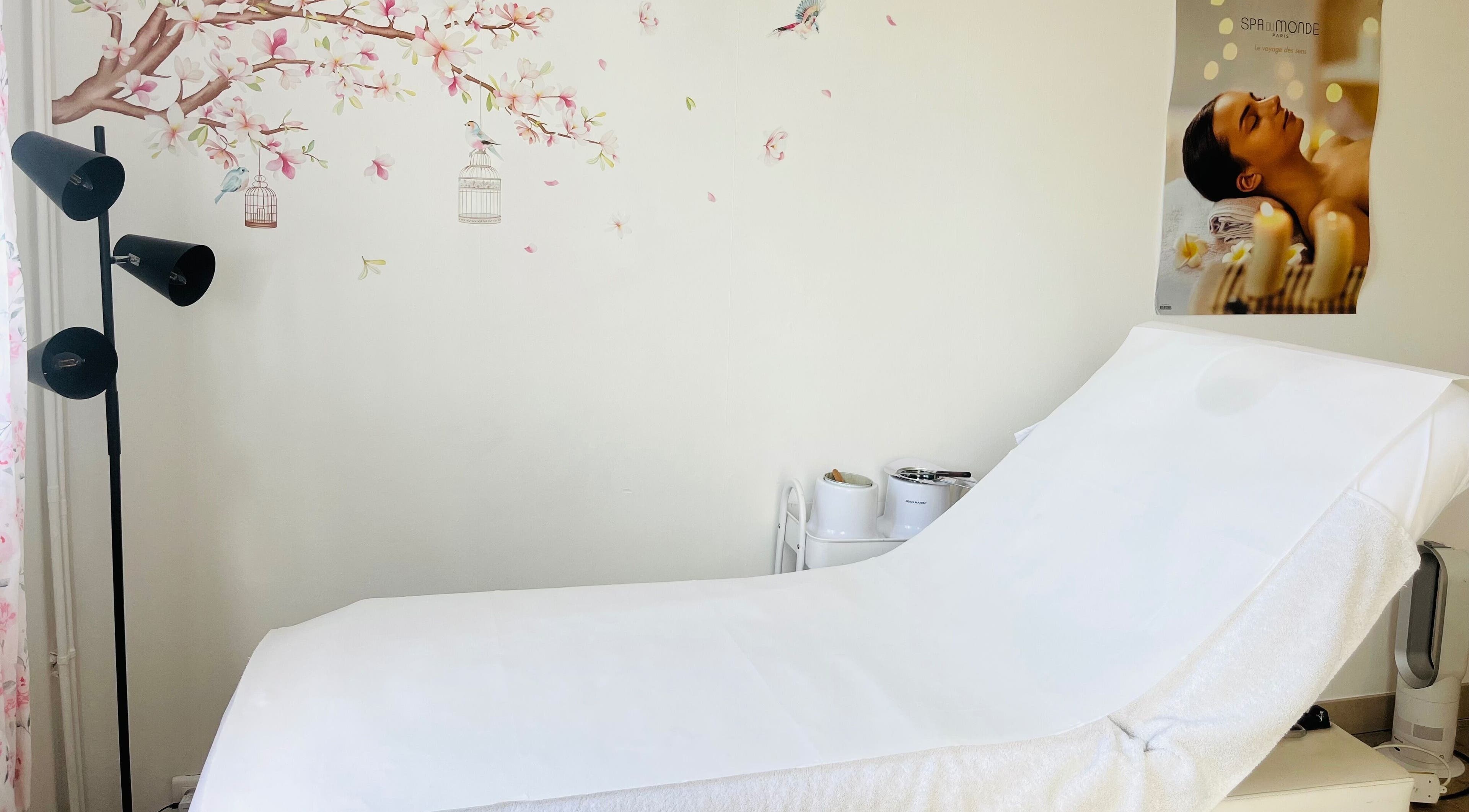 Salle de soins à Celestiminstitut, Saint-lyé, Grand Est, FR, avec lit de massage et décoration florale.