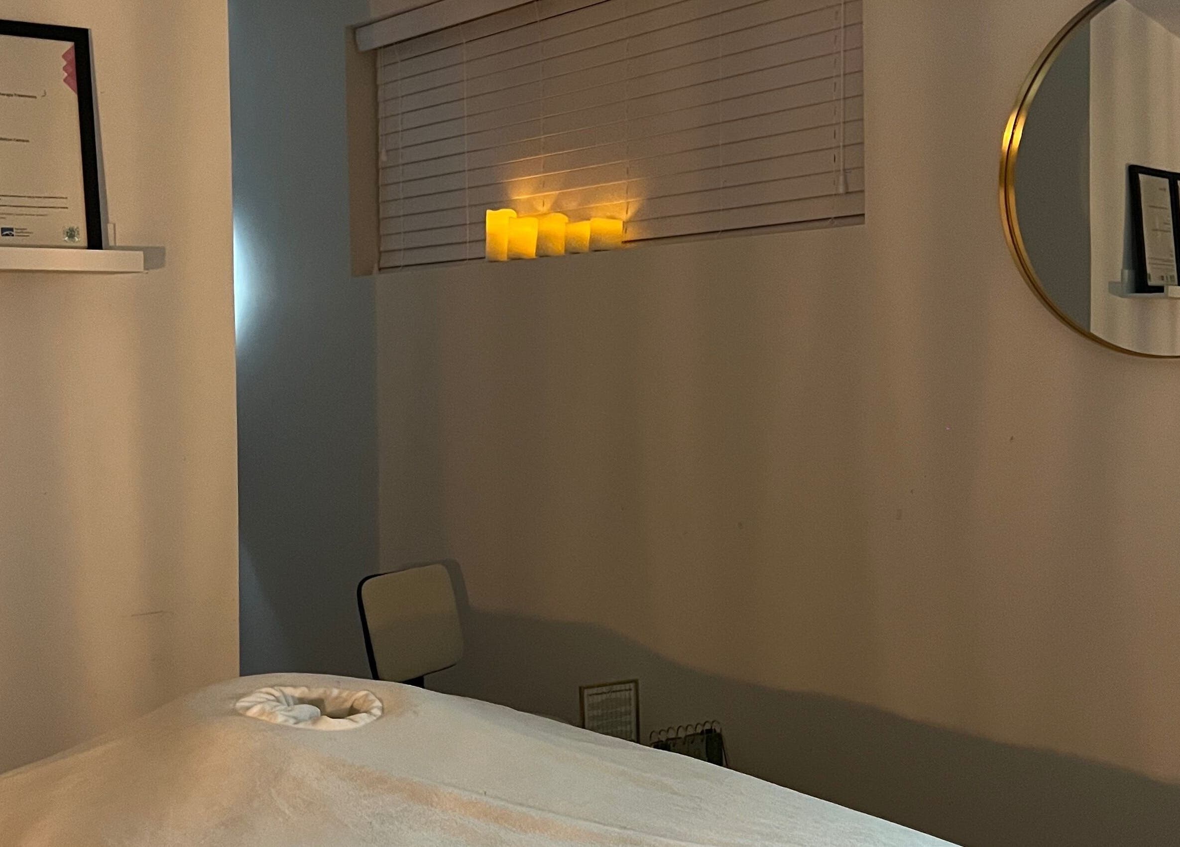 Cozy massage room at Liberty's Wellness Retreat, Melton Mowbray, England, GB, with soft candlelight ambiance.