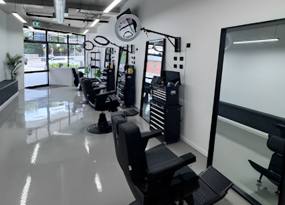 Modern interior of Elevate Barber Studio in Stanmore, New South Wales, AU showcasing sleek chairs and mirrors.