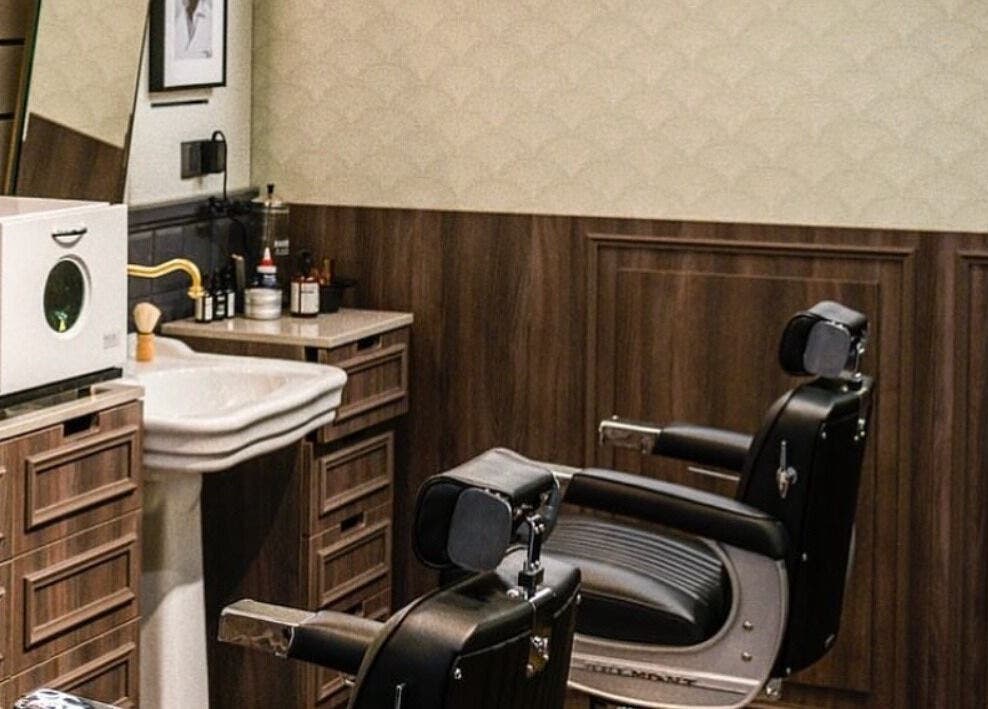 صالون Bull Frog الحديث في مسقط، محافظة مسقط، مزود بمقاعد حلاقة أنيقة وتفاصيل خشبية فاخرة.