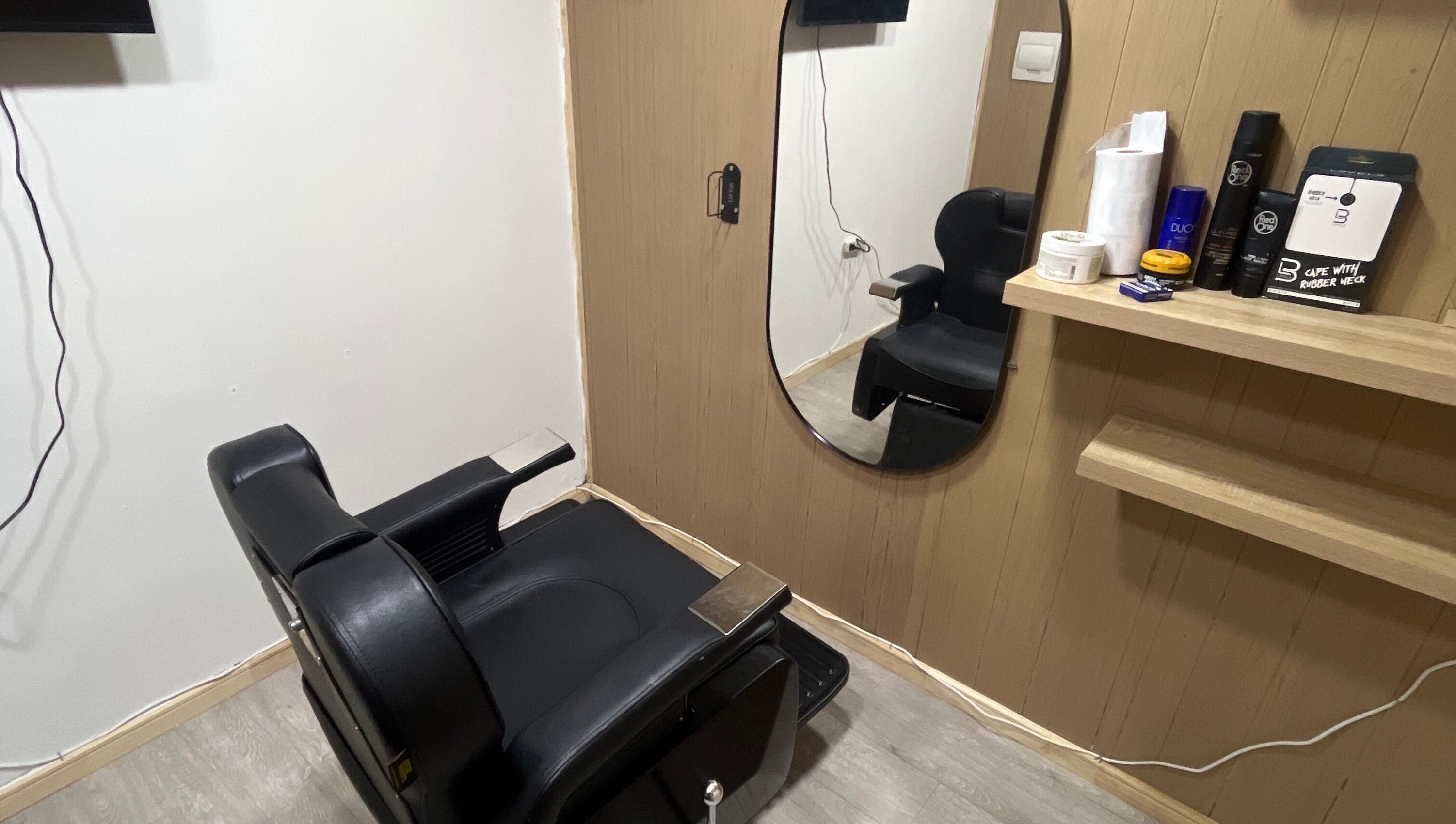 Sala de peluquería moderna en Thony Estilo, Puerto Montt, Los Lagos, CL. Sillón negro y espejo elegante.