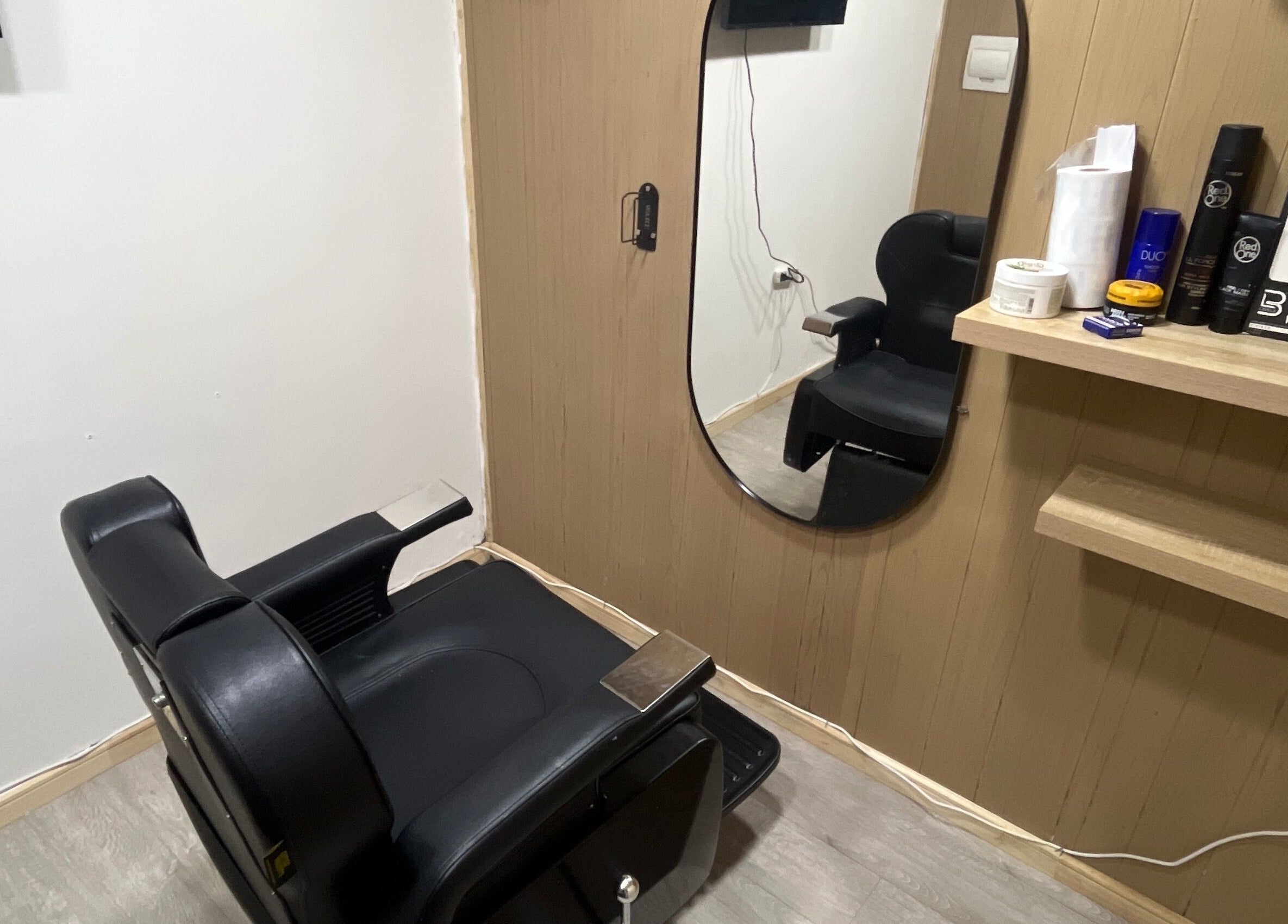 Sala de peluquería moderna en Thony Estilo, Puerto Montt, Los Lagos, CL. Sillón negro y espejo elegante.