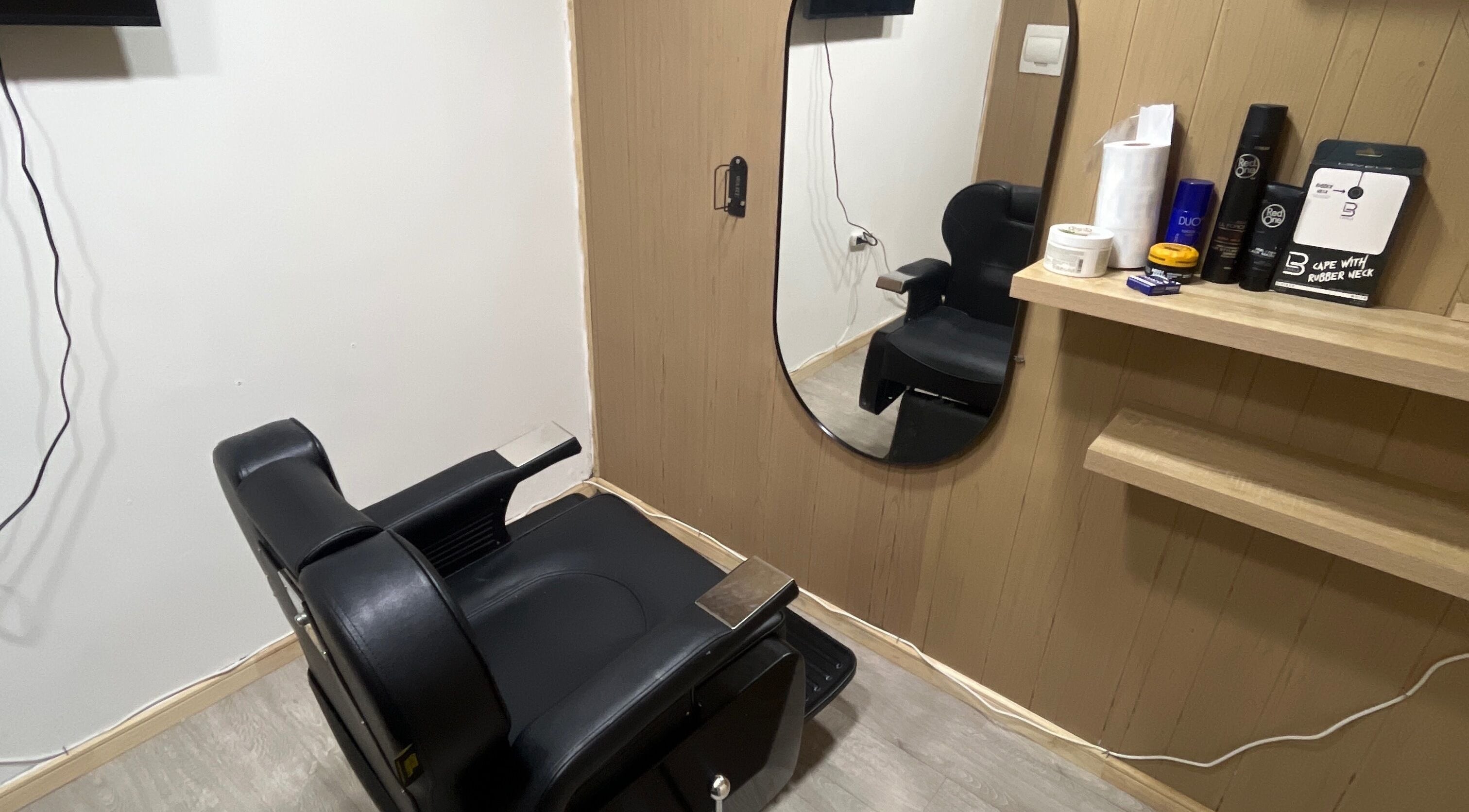 Sala de peluquería moderna en Thony Estilo, Puerto Montt, Los Lagos, CL. Sillón negro y espejo elegante.