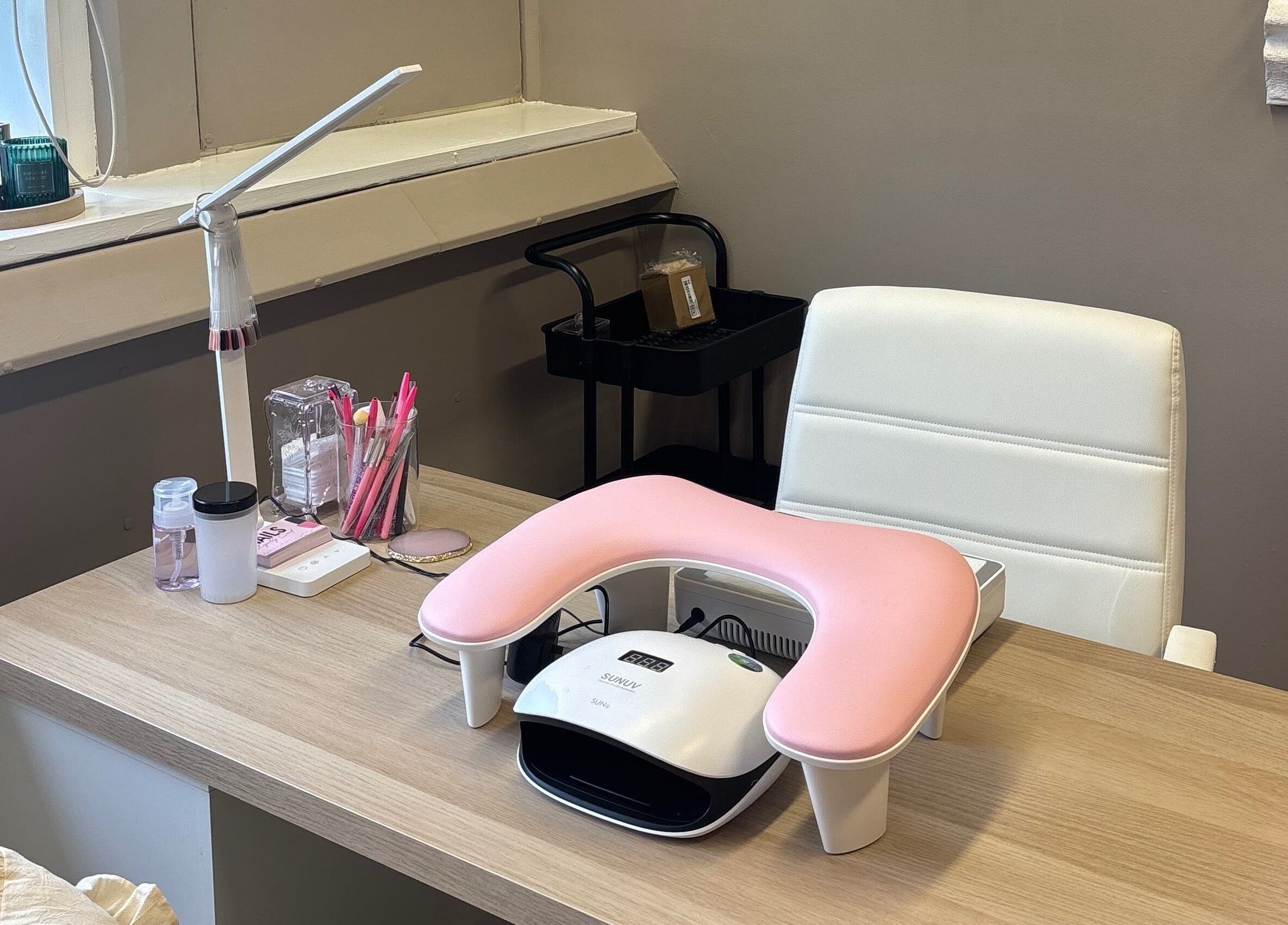 Nail station at Carved by Chloe in Livingston, Scotland, GB with tools and a white armchair.