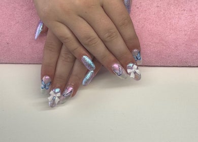 Beautiful butterfly nail art at Nails By Corrina in Lethbridge Park, New South Wales, AU on a pink towel.