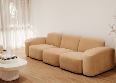 Stylish beige sofa in Fleek Aesthetics lounge, Mount Pleasant, Queensland, AU, providing a chic, relaxing atmosphere.