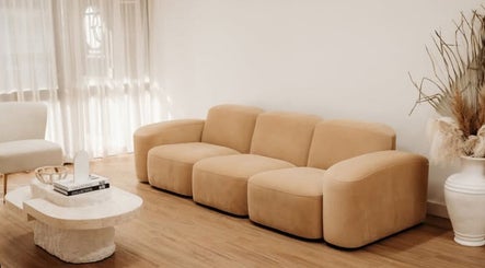 Stylish beige sofa in Fleek Aesthetics lounge, Mount Pleasant, Queensland, AU, providing a chic, relaxing atmosphere.