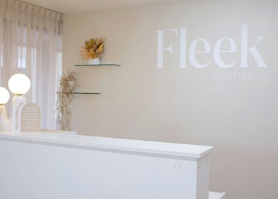 Reception desk at Fleek Aesthetics in Mount Pleasant, Queensland, AU, offering a warm, minimalist ambiance.