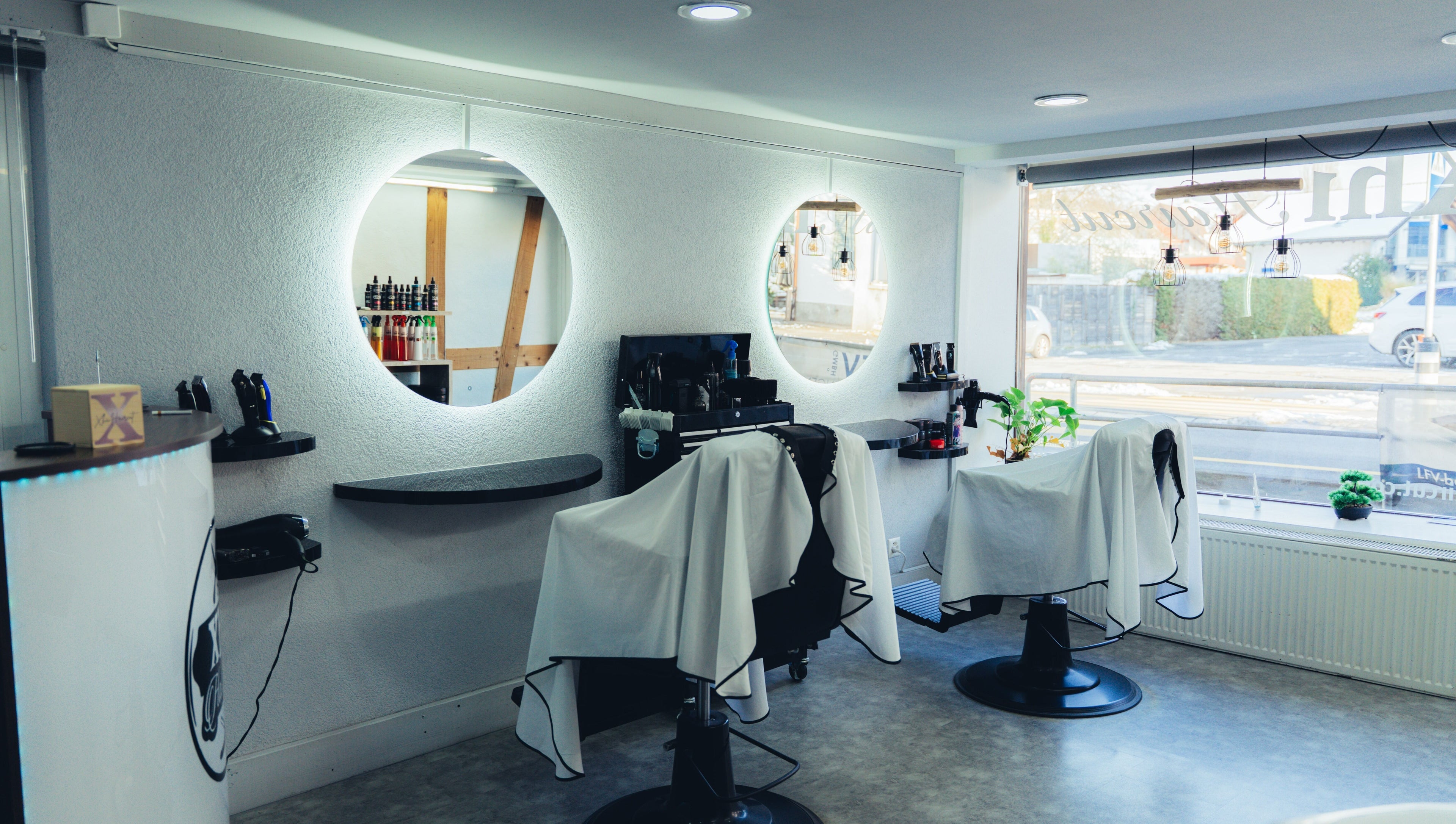 Moderner Friseursalon bei Abifades in Thun, Bern, CH mit stilvollen Spiegeln und Friseurstühlen.