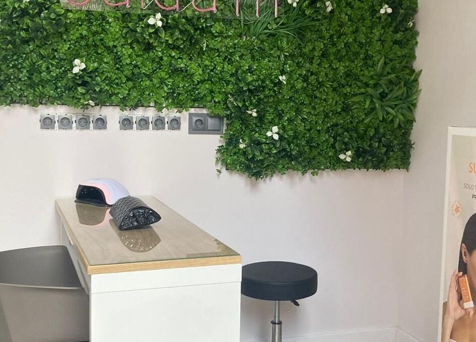Sala de belleza Cuida'm en Montcada I Reixac, Catalunya, ES con pared de plantas y puesto de manicura.