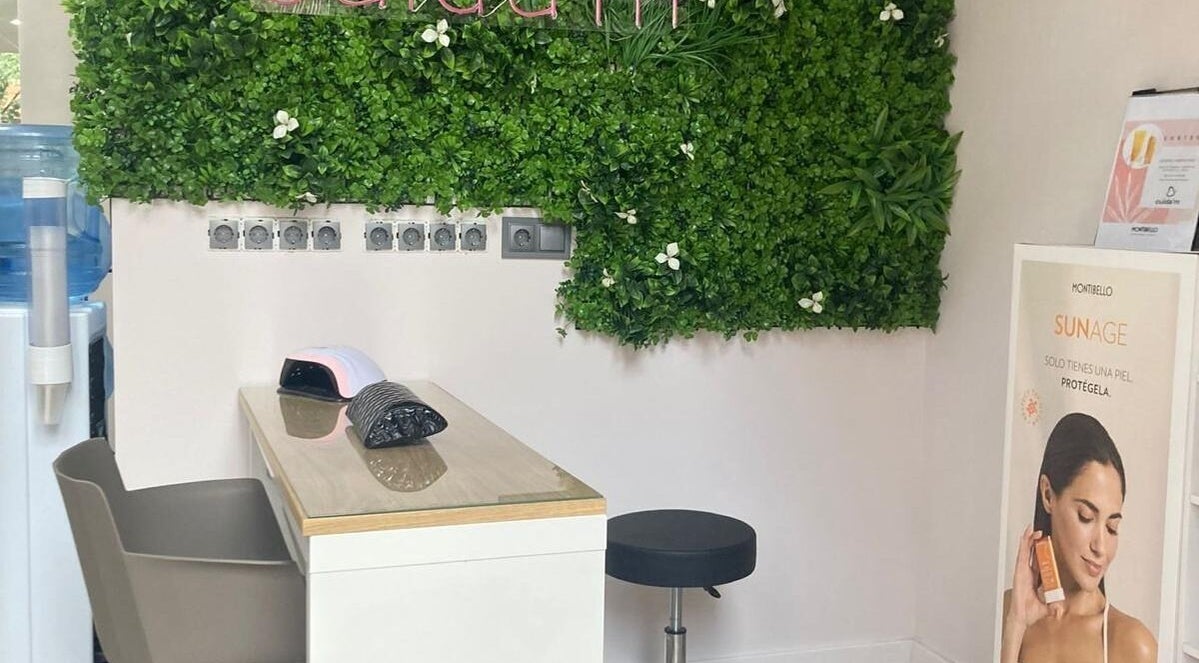 Sala de belleza Cuida'm en Montcada I Reixac, Catalunya, ES con pared de plantas y puesto de manicura.