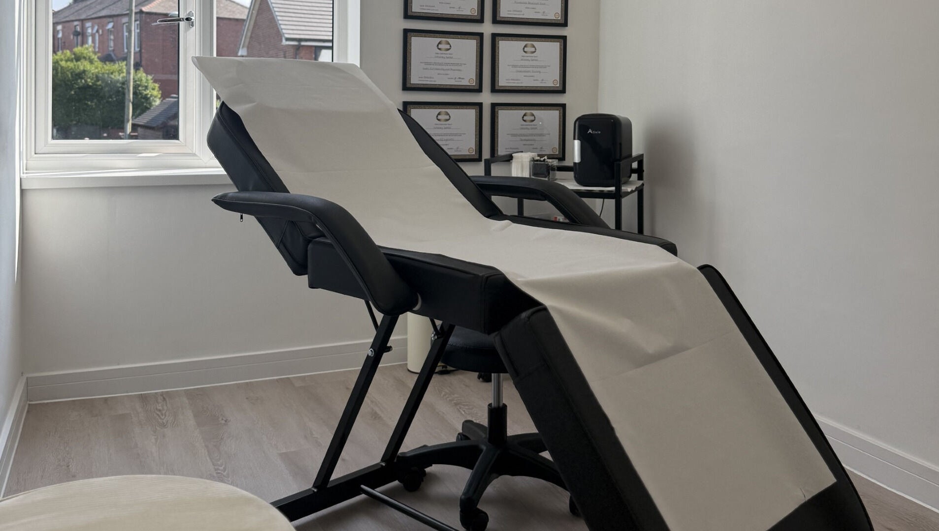 Sleek aesthetic treatment room at Perfect Profile Aesthetics in Middleton, England, GB, with a comfortable chair.
