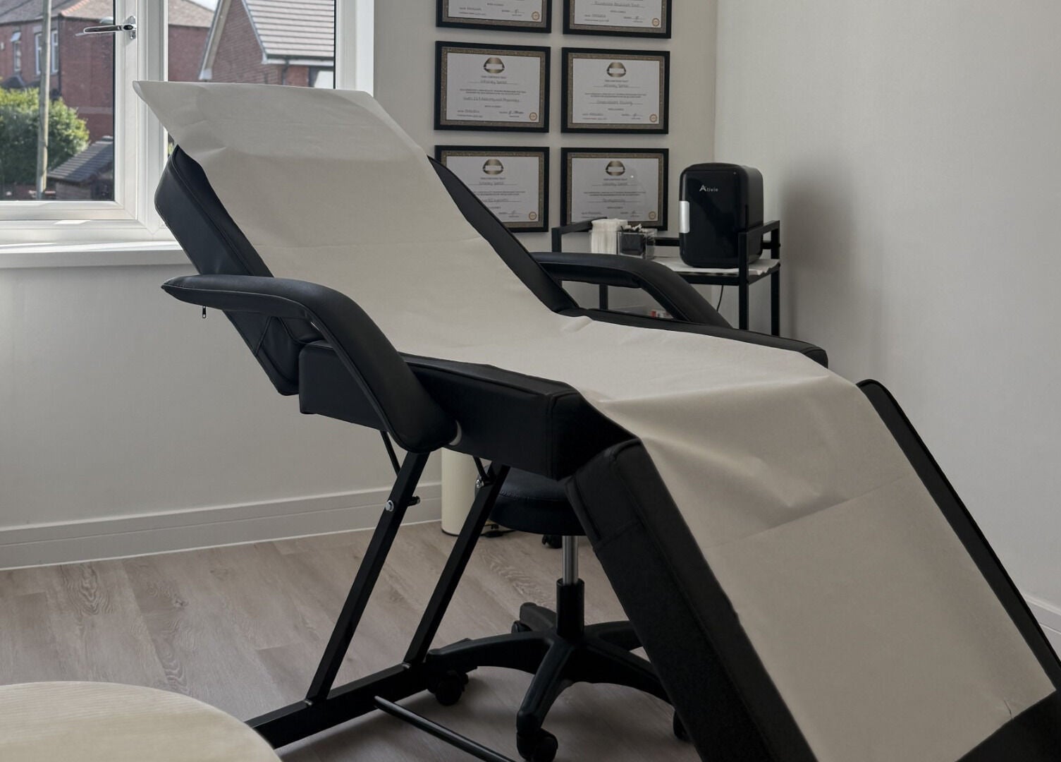 Sleek aesthetic treatment room at Perfect Profile Aesthetics in Middleton, England, GB, with a comfortable chair.