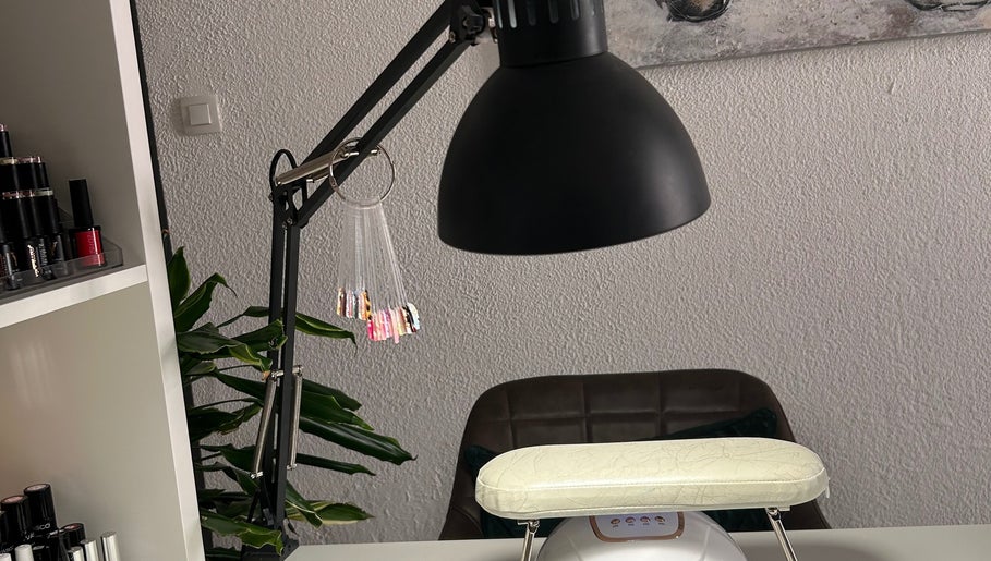 Table de manucure à L’onglerie de Lau, Castries, Occitanie, FR, avec lampe et échantillons de vernis.