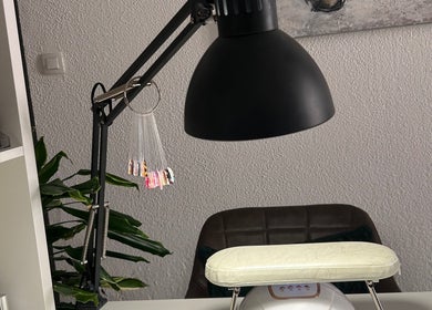 Table de manucure à L’onglerie de Lau, Castries, Occitanie, FR, avec lampe et échantillons de vernis.