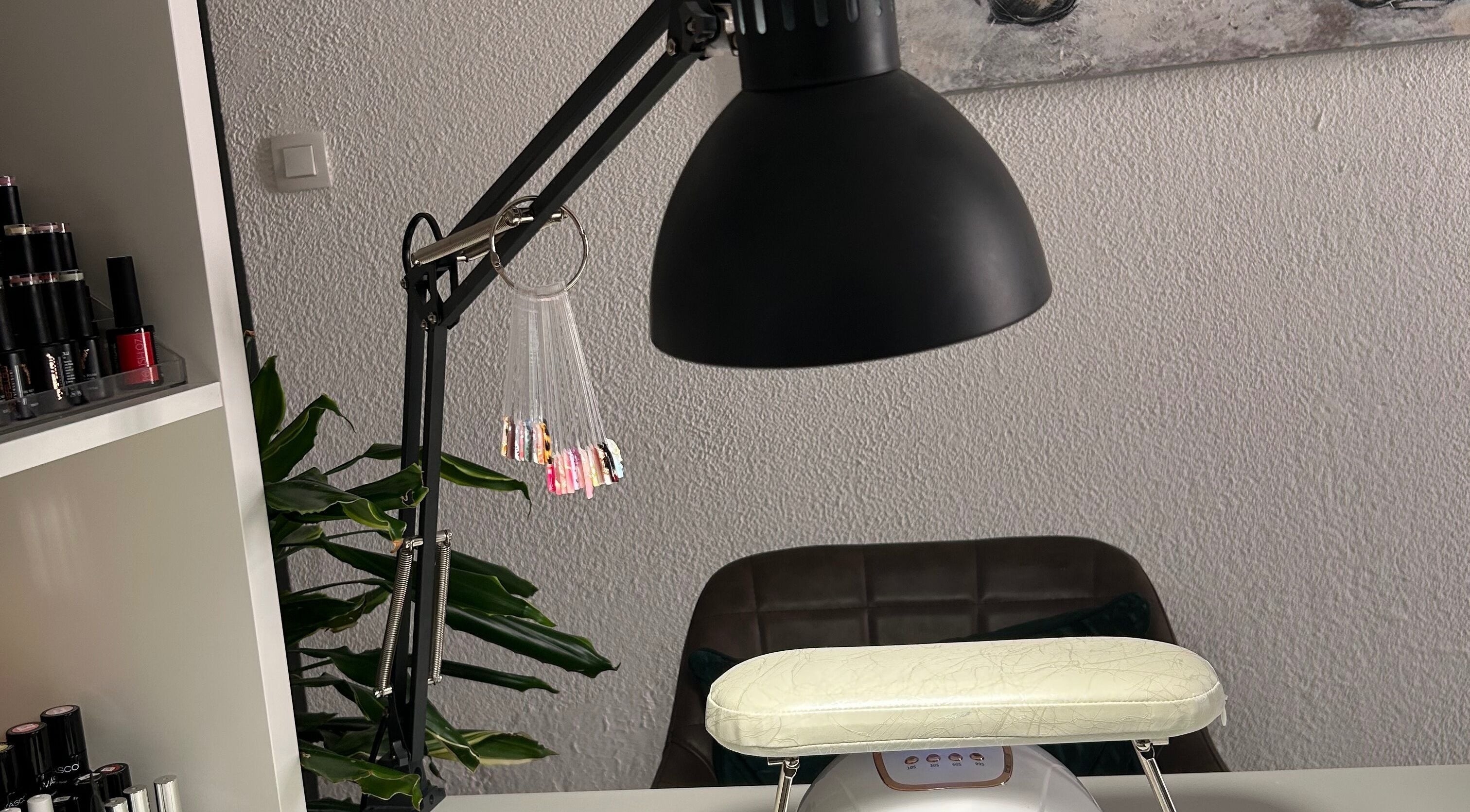 Table de manucure à L’onglerie de Lau, Castries, Occitanie, FR, avec lampe et échantillons de vernis.