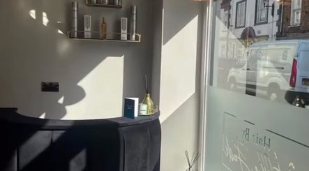 Sunlit interior of Charlotte Olivia Hair, Goole, England, highlighting sleek decor and elegant product display.