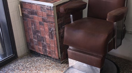 Sedia da barbiere in pelle marrone presso Pepe Barber shop, Roma, Lazio, IT.