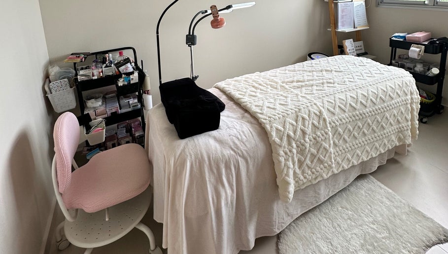 Serene aesthetic treatment room at Vilash Studio, Singapura, SG, featuring a plush bed and organized amenities.