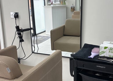Comfortable salon setting at Hairbyaliceemma, Derby, England, GB with styling tools and mirror.