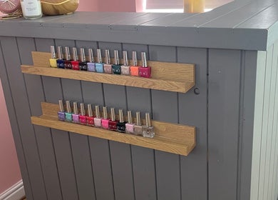 Colorful nail polish display at Lyndsay’s Beauty in Bottesford, England, GB on a stylish grey counter.