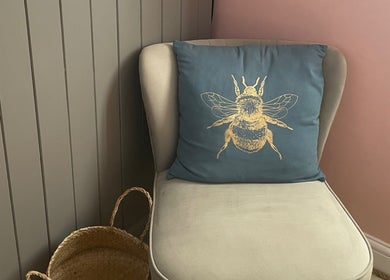 Elegant chair with bee cushion in Lyndsay's Beauty, Bottesford, England, GB. Inviting corner decor.