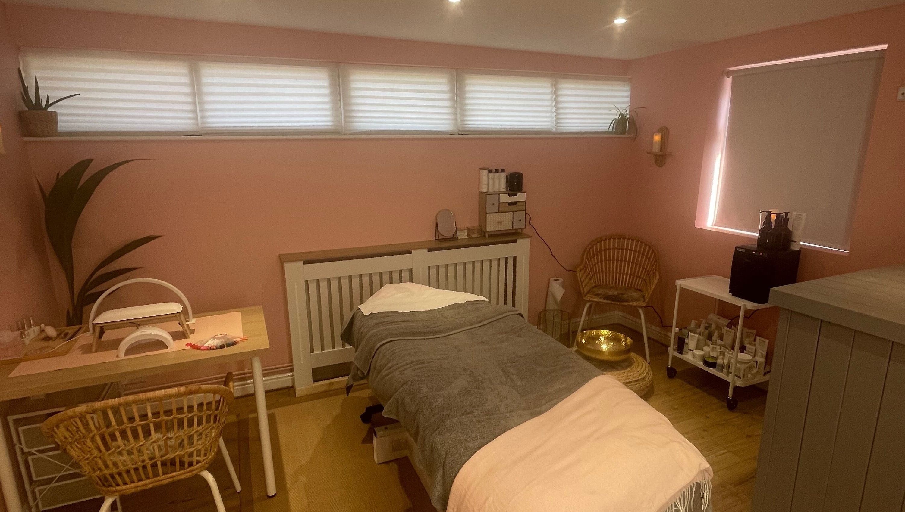 Tranquil treatment room at Lyndsay’s Beauty, Bottesford, England, GB with soothing pink walls and comfortable furnishings.