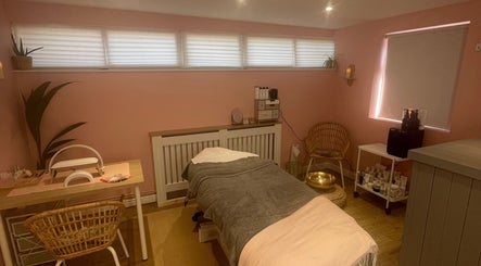 Tranquil treatment room at Lyndsay’s Beauty, Bottesford, England, GB with soothing pink walls and comfortable furnishings.