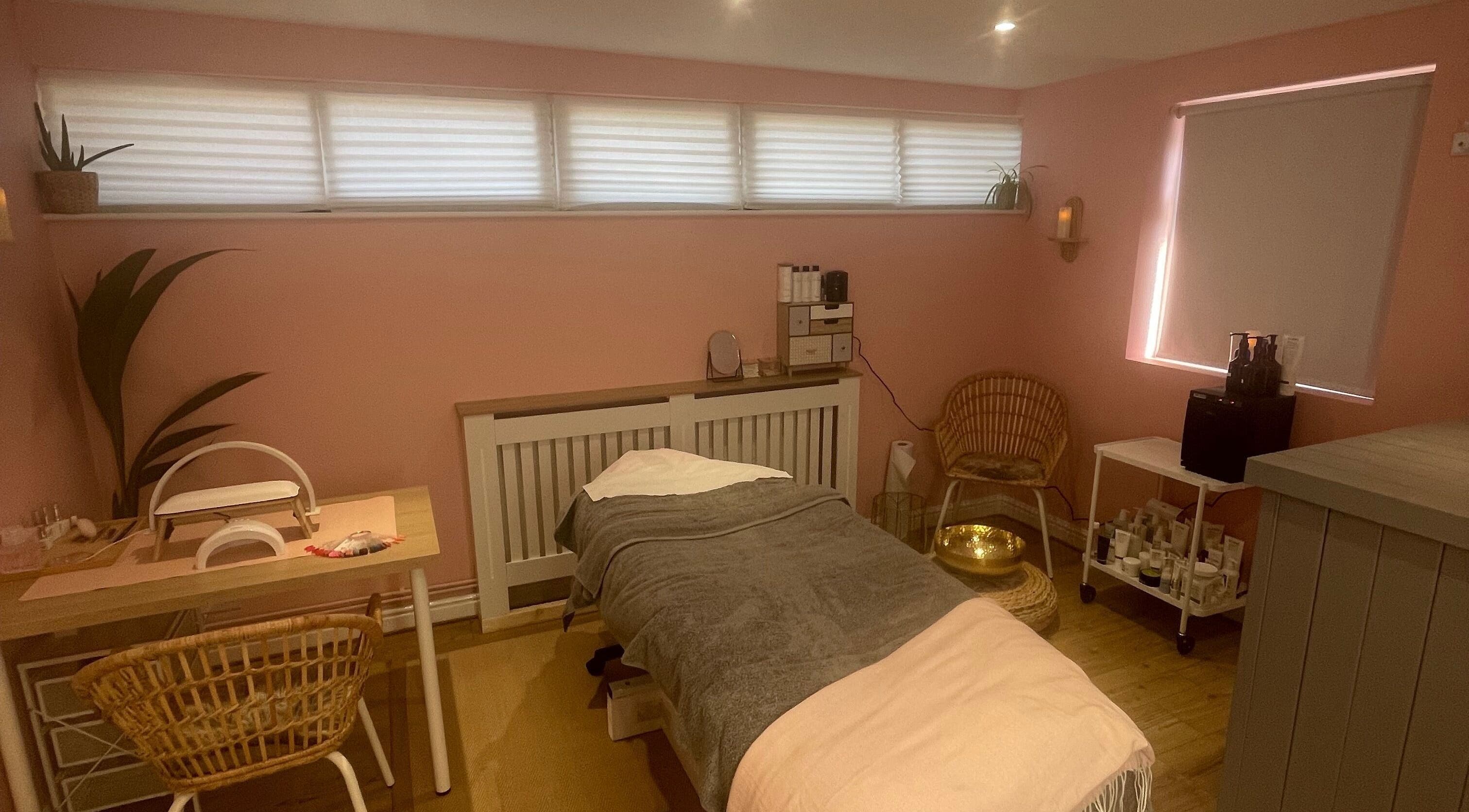 Tranquil treatment room at Lyndsay’s Beauty, Bottesford, England, GB with soothing pink walls and comfortable furnishings.