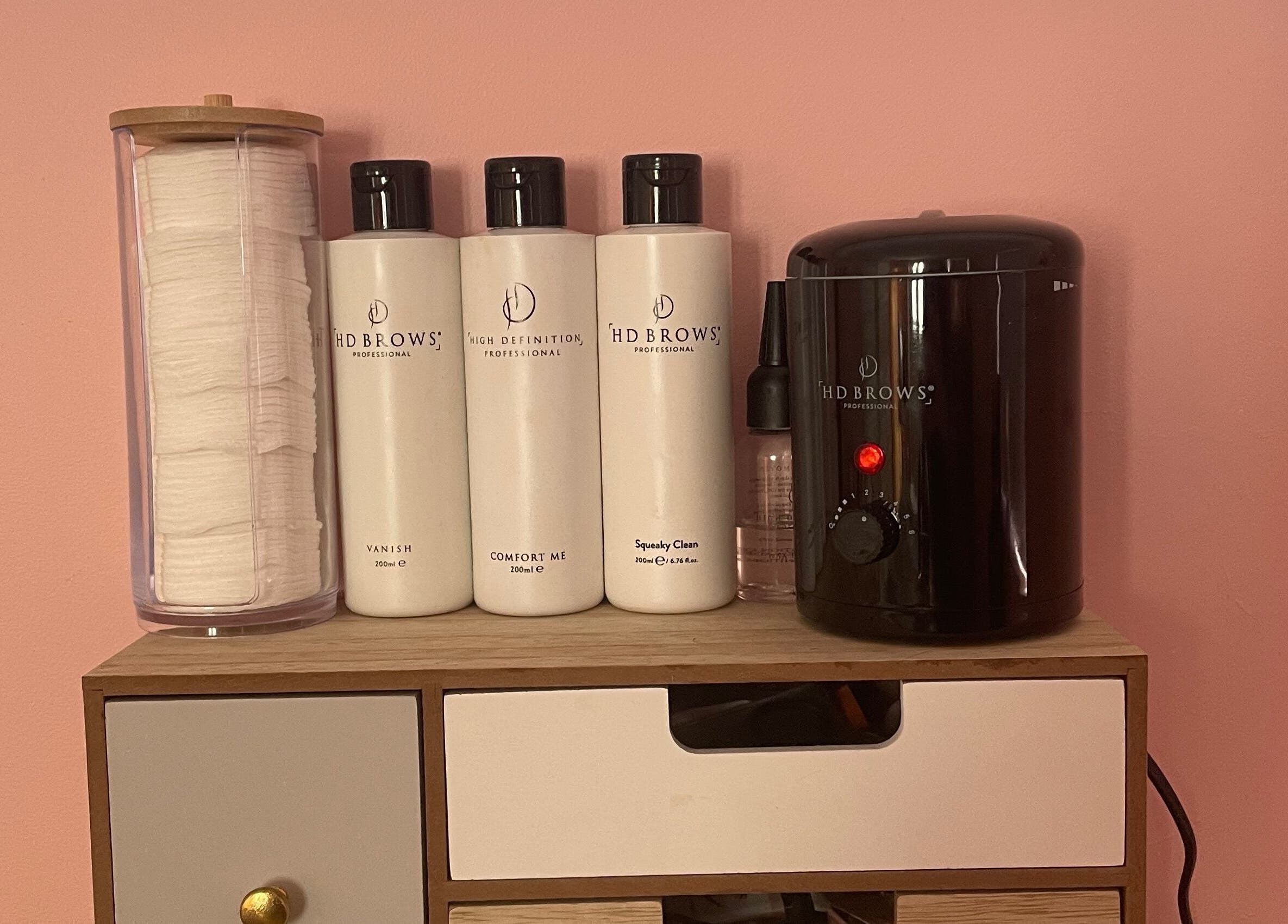 HD Brows products at Lyndsay’s Beauty in Bottesford, England, GB, on a wooden shelf against a pink wall.