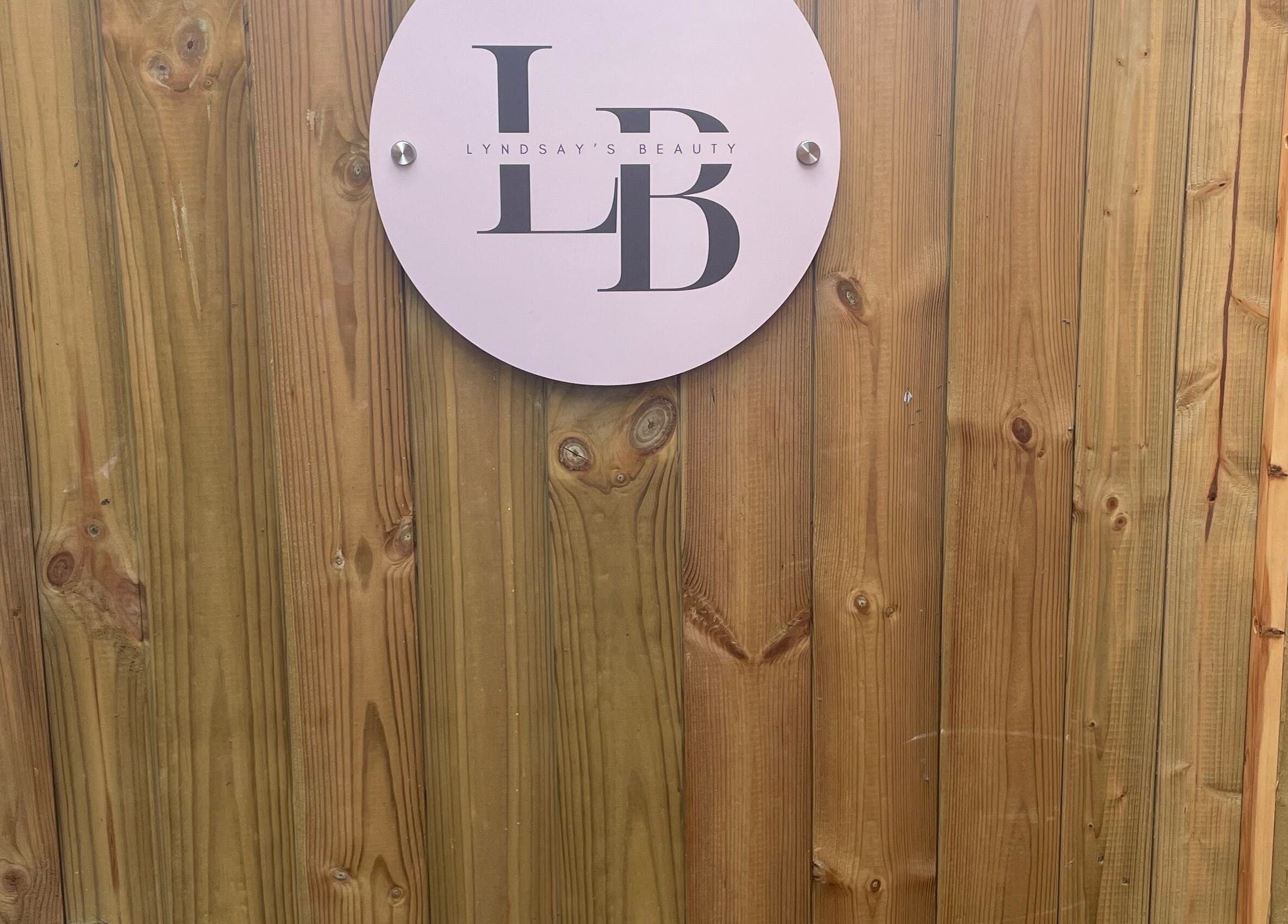Wooden door with Lyndsay’s Beauty sign at Bottesford, England, GB.