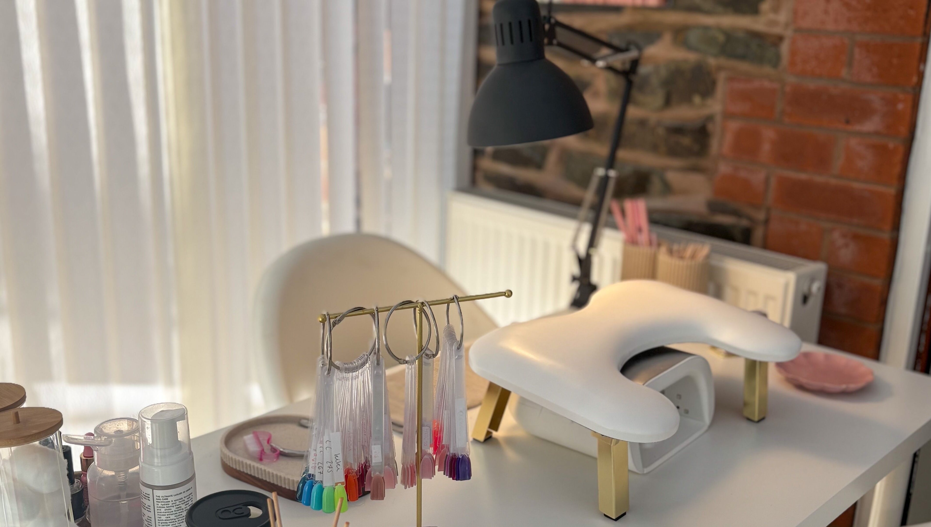 Bright manicure station at Gels by Meg in Welshpool, Wales, GB, featuring nail color samples and equipment.