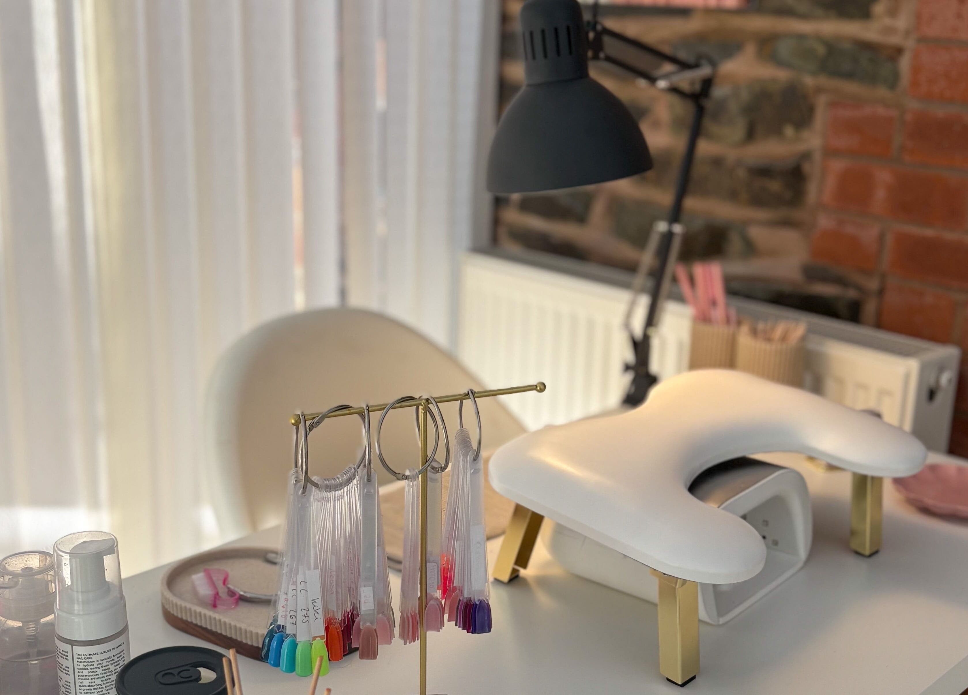 Bright manicure station at Gels by Meg in Welshpool, Wales, GB, featuring nail color samples and equipment.