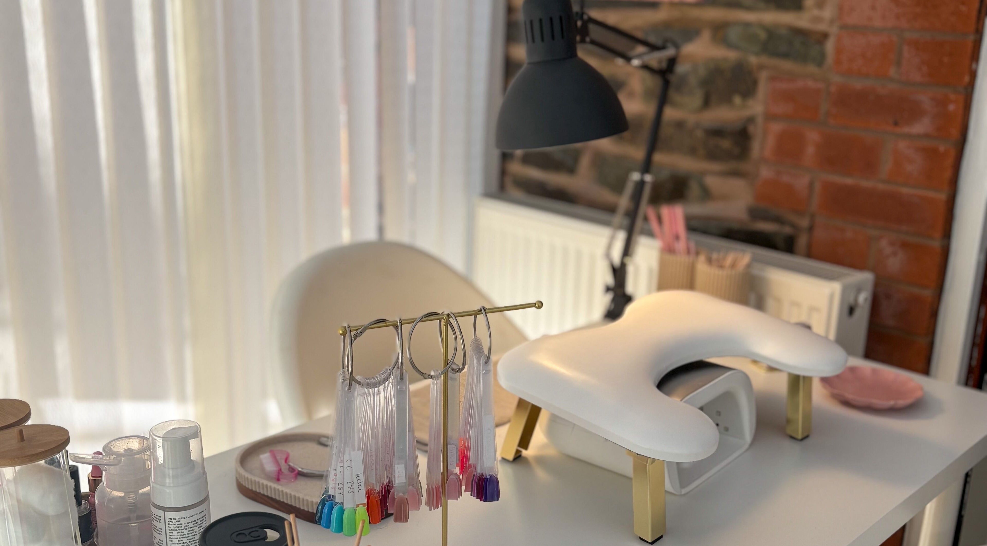 Bright manicure station at Gels by Meg in Welshpool, Wales, GB, featuring nail color samples and equipment.